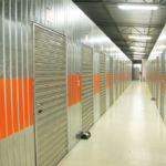 Corredor interno de self storage Mogi das Cruzes, com boxes metálicos individuais alinhados, iluminação adequada e estrutura organizada para armazenamento seguro.