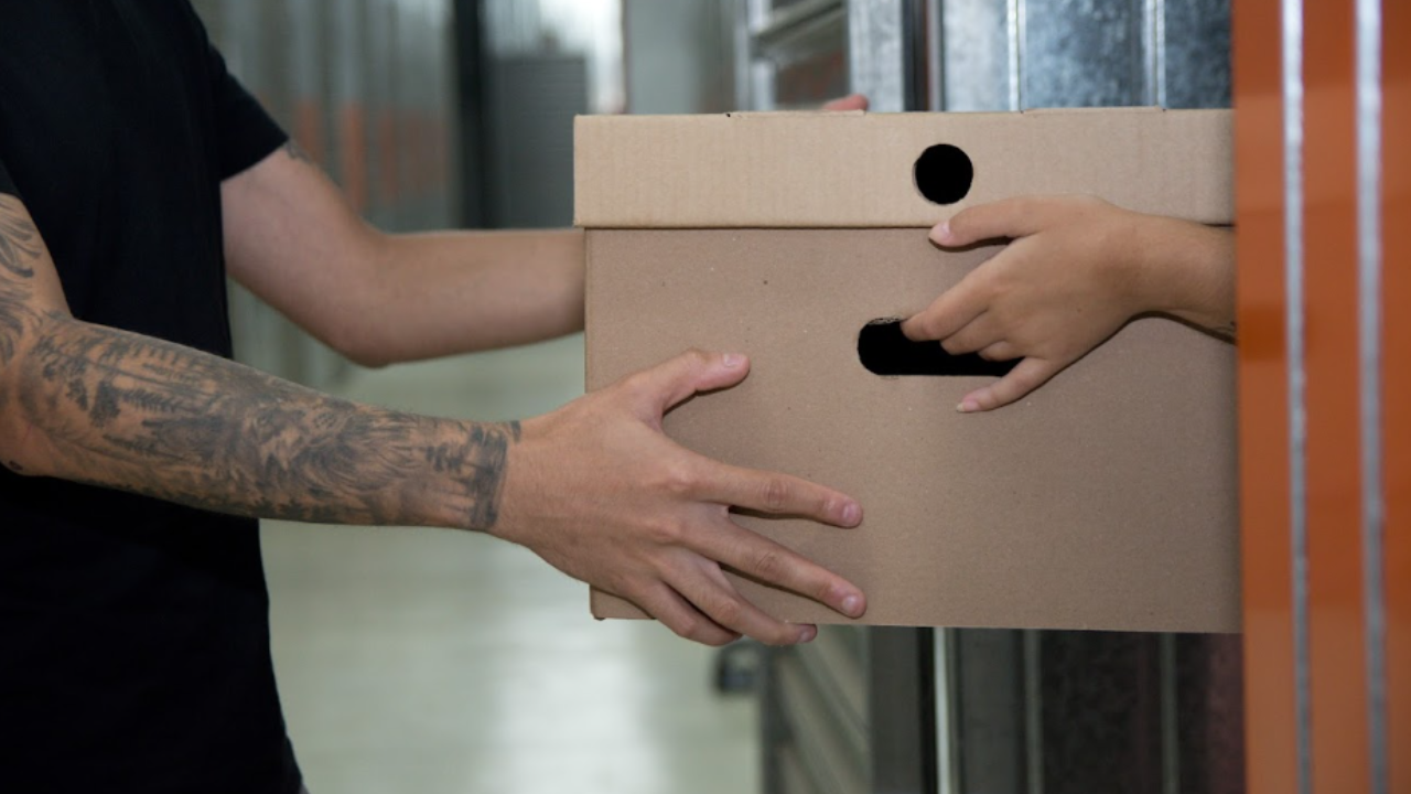 Pessoa entregando uma caixa de papelão no Mogibox, um selfstorage.